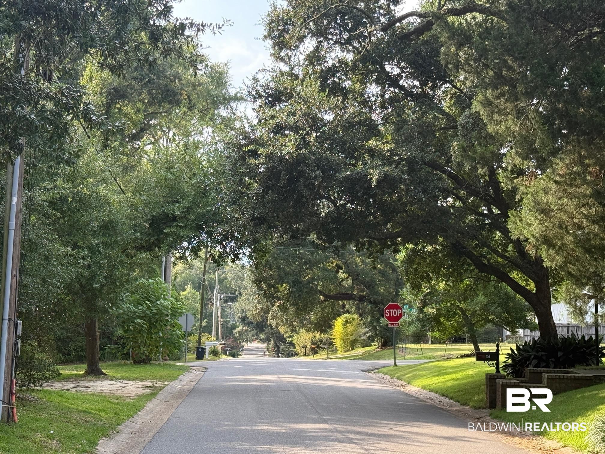 156 Pier Avenue Fairhope, AL 36532 - Photo 41 of 41 View of asphalt road with traffic signs and view of wooded area