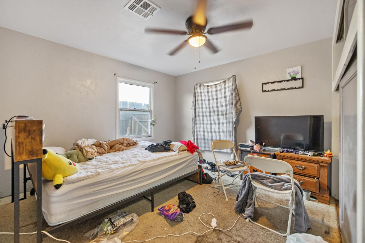 821 Lincoln Street Hanford, CA 93230 - Photo 13 of 22 a bedroom with a bed and a flat screen tv