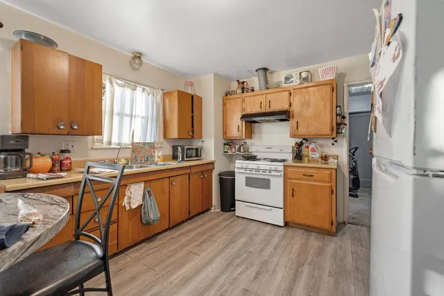 a kitchen with granite countertop white cabinets and white appliances