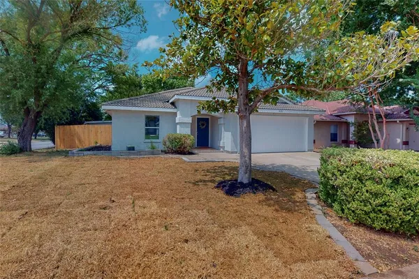 a front view of house with yard and trees around