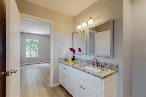 a bathroom with a sink vanity and a mirror