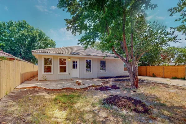 a view of a house with backyard and trees