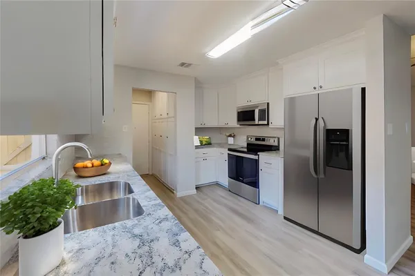 a kitchen with stainless steel appliances granite countertop a refrigerator and a sink