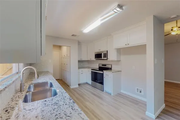 a kitchen with stainless steel appliances granite countertop a sink stove refrigerator and granite counter top