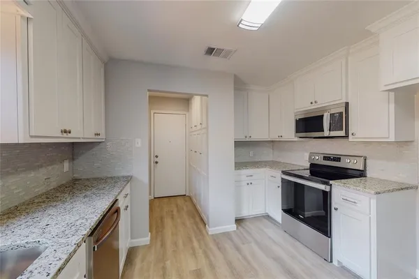 a kitchen with granite countertop a stove top oven and sink