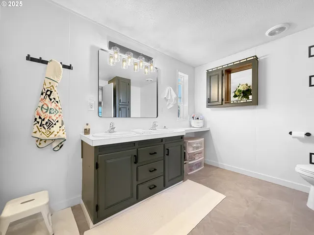 a spacious bathroom with a double vanity sink and a mirror