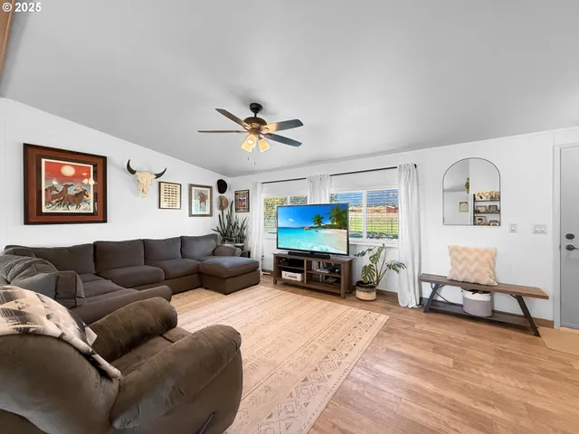 a living room with furniture and a flat screen tv with kitchen view