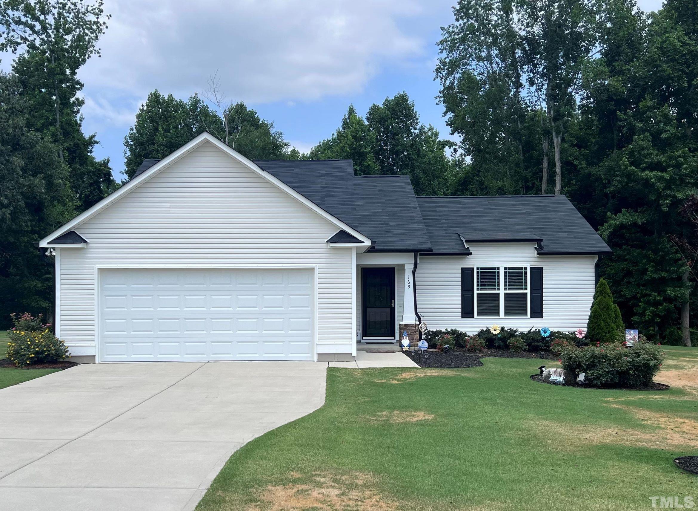 169 Willow Ridge Circle Willow Spring, NC 27592 - Photo 1 of 30 a backyard of a house with table and chairs plants and trees