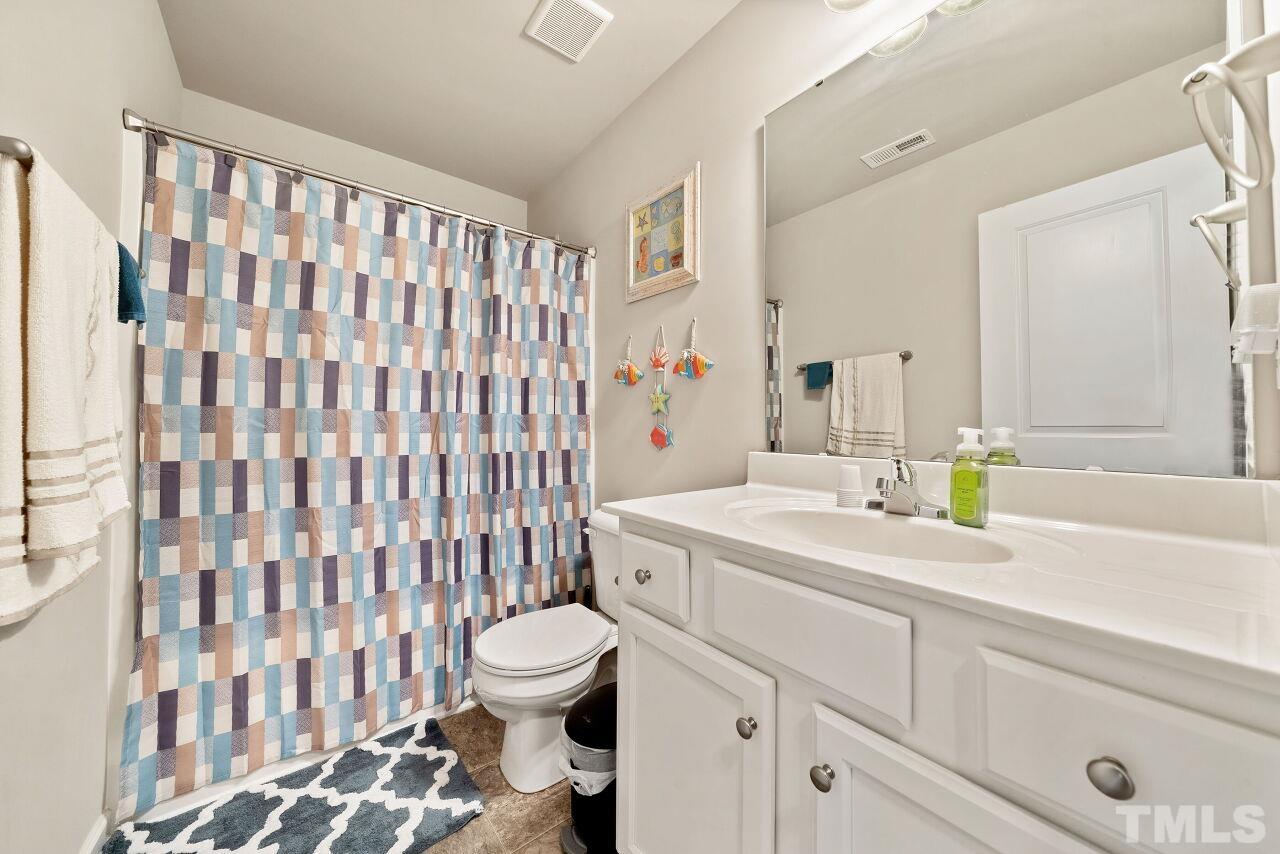 169 Willow Ridge Circle Willow Spring, NC 27592 - Photo 16 of 30 a bathroom with a sink a toilet and a shower curtain