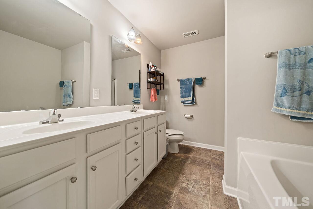 169 Willow Ridge Circle Willow Spring, NC 27592 - Photo 20 of 30 a spacious bathroom with a double vanity sink mirror and toilet
