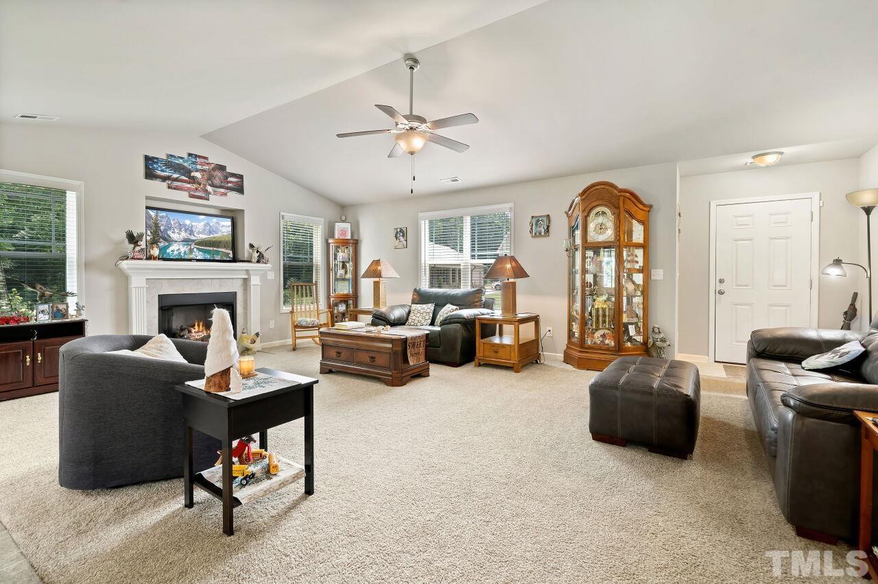 169 Willow Ridge Circle Willow Spring, NC 27592 - Photo 5 of 30 a living room with furniture a fireplace and a flat screen tv