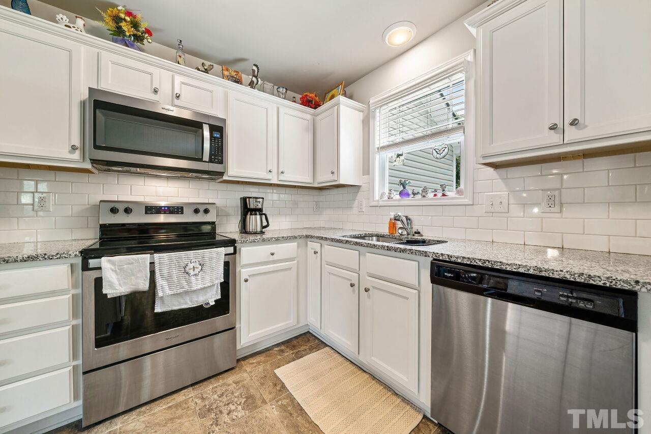 169 Willow Ridge Circle Willow Spring, NC 27592 - Photo 8 of 30 a kitchen with stainless steel appliances granite countertop a sink a stove a microwave and cabinets