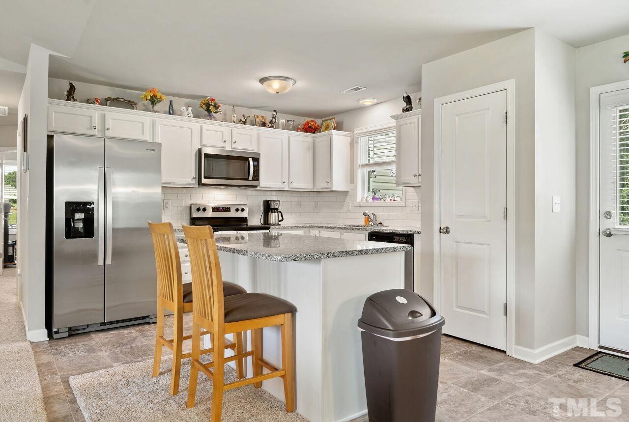169 Willow Ridge Circle Willow Spring, NC 27592 - Photo 9 of 30 a kitchen with stainless steel appliances granite countertop a refrigerator and a stove top oven