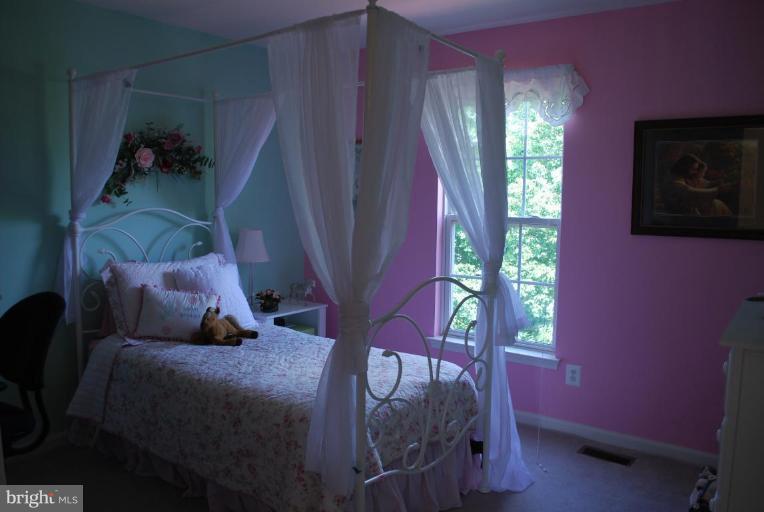 42699 Middle Ridge Place Ashburn, VA 20148 - Photo 8 of 12 a bed sitting in a bedroom next to a window