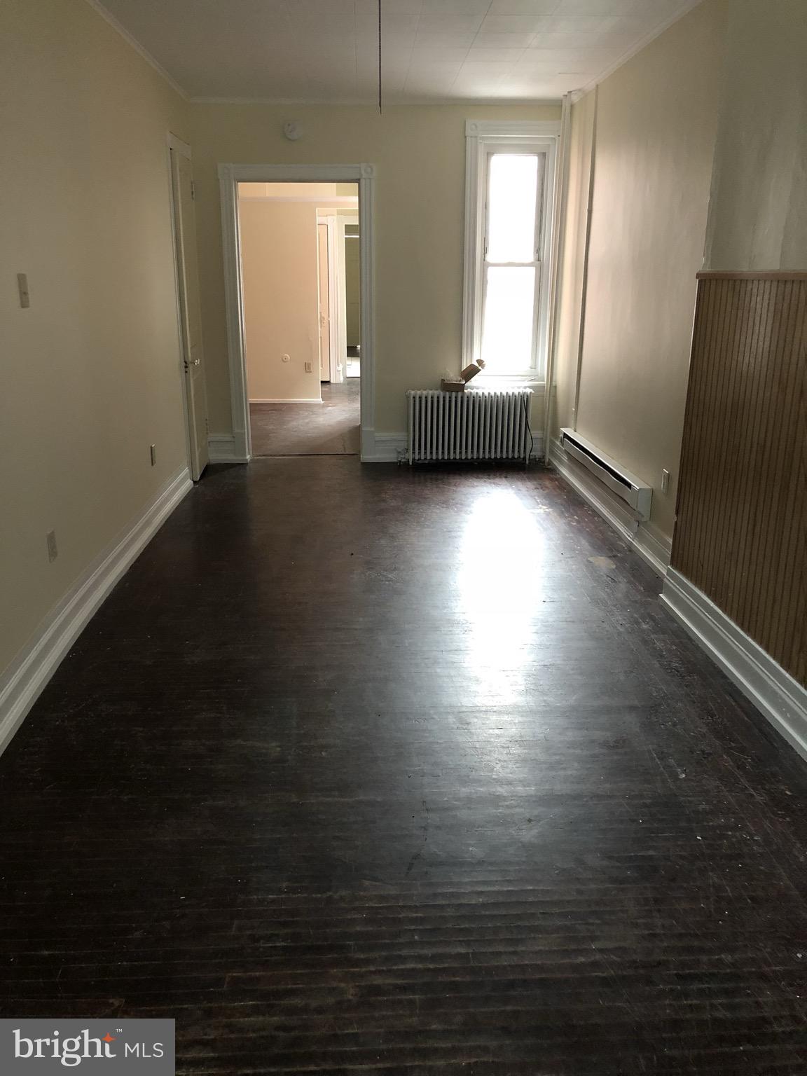 815 Weiser Street Reading, PA 19601 - Photo 4 of 19 an empty room with wooden floor and windows