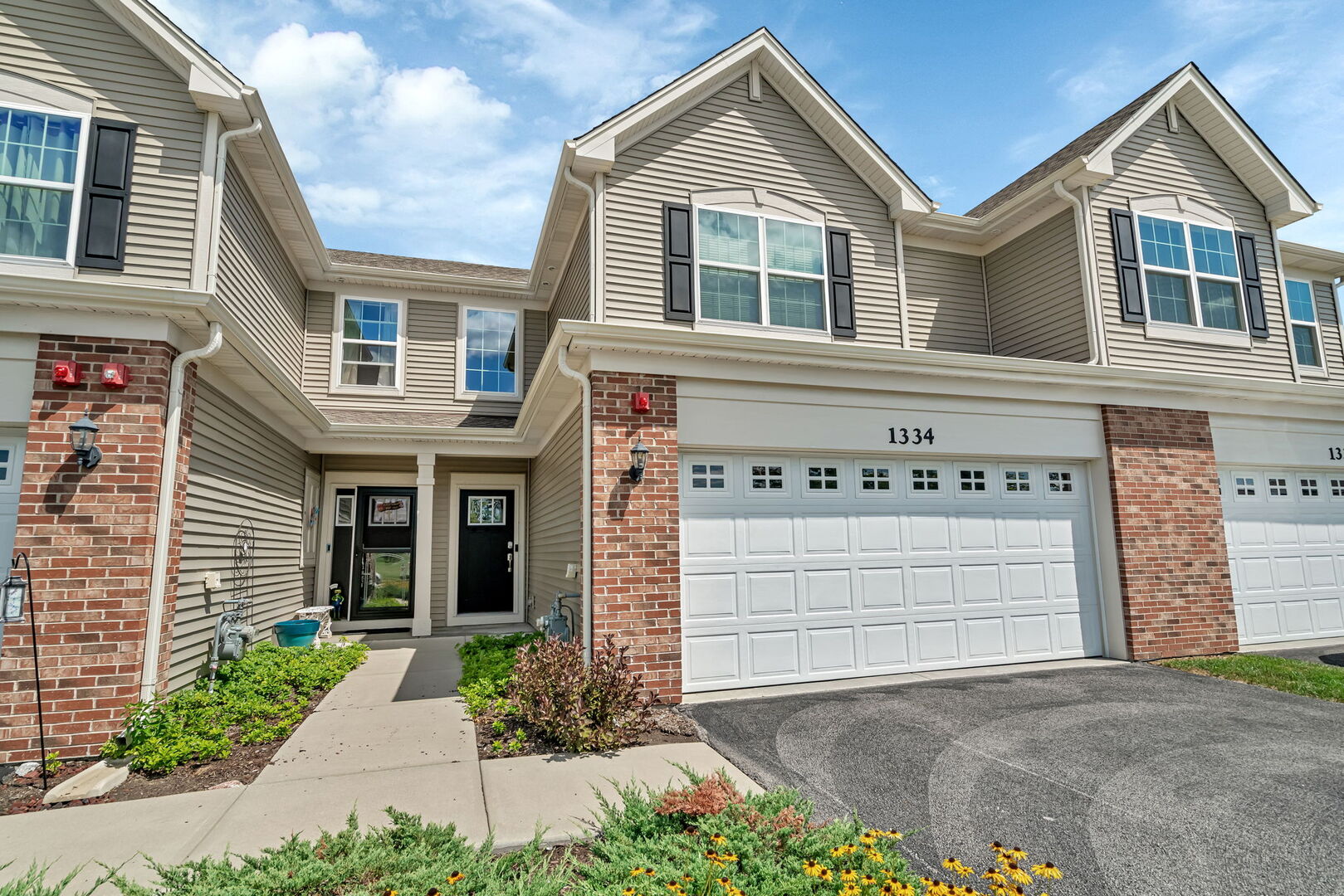 1334 Hawk Hollow Drive Yorkville, IL 60560 - Photo 1 of 28 a front view of a house with a yard and garage