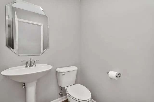 a bathroom with a toilet a sink and mirror