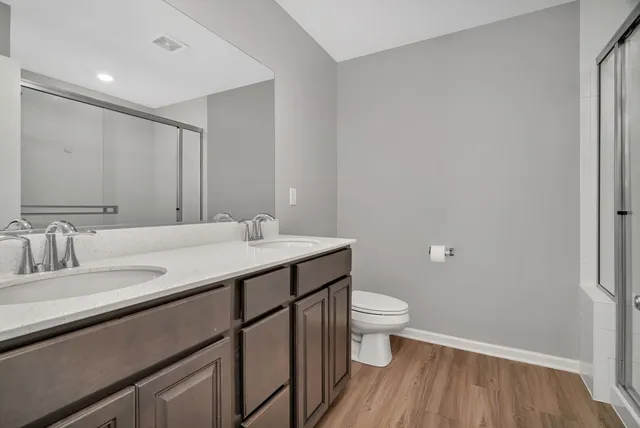 a bathroom with a granite countertop sink a toilet and a mirror
