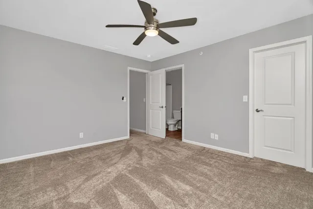 a view of an empty room and chandelier fan