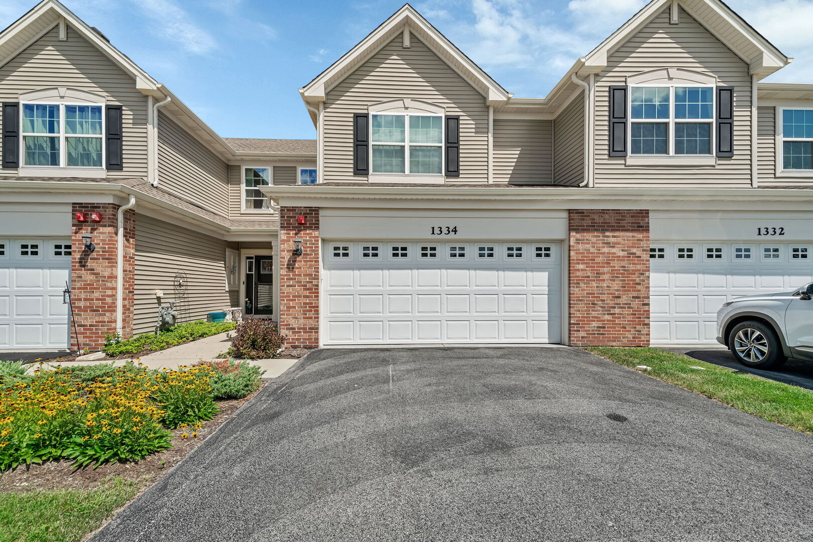 1334 Hawk Hollow Drive Yorkville, IL 60560 - Photo 2 of 28 a front view of a house with a yard and garage