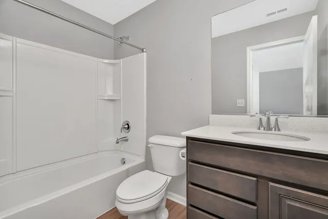 a bathroom with a granite countertop sink toilet a mirror and shower