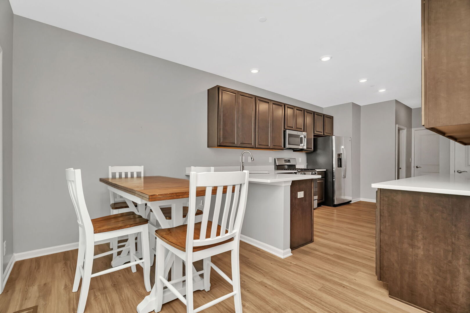 1334 Hawk Hollow Drive Yorkville, IL 60560 - Photo 8 of 28 a kitchen with stainless steel appliances kitchen island granite countertop a table chairs stove microwave and cabinets