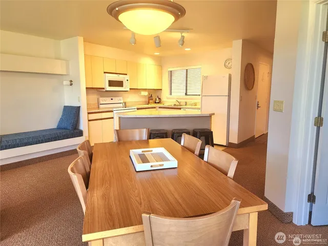 a living room with stainless steel appliances furniture stove and kitchen view