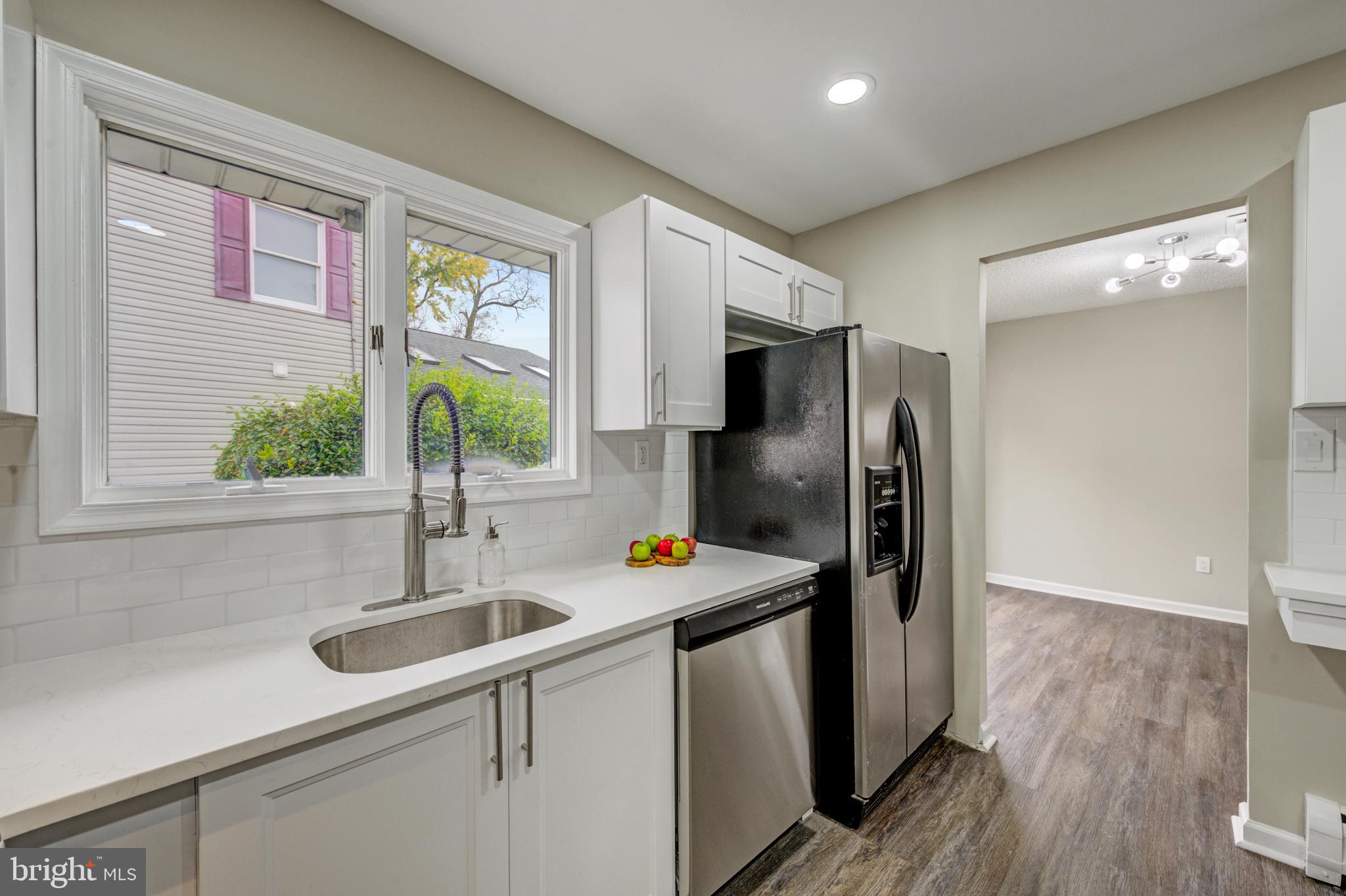 4255 Somerton Road Feasterville-Trevose, PA 19053 - Photo 7 of 37 a kitchen with stainless steel appliances granite countertop a sink refrigerator and wooden floor