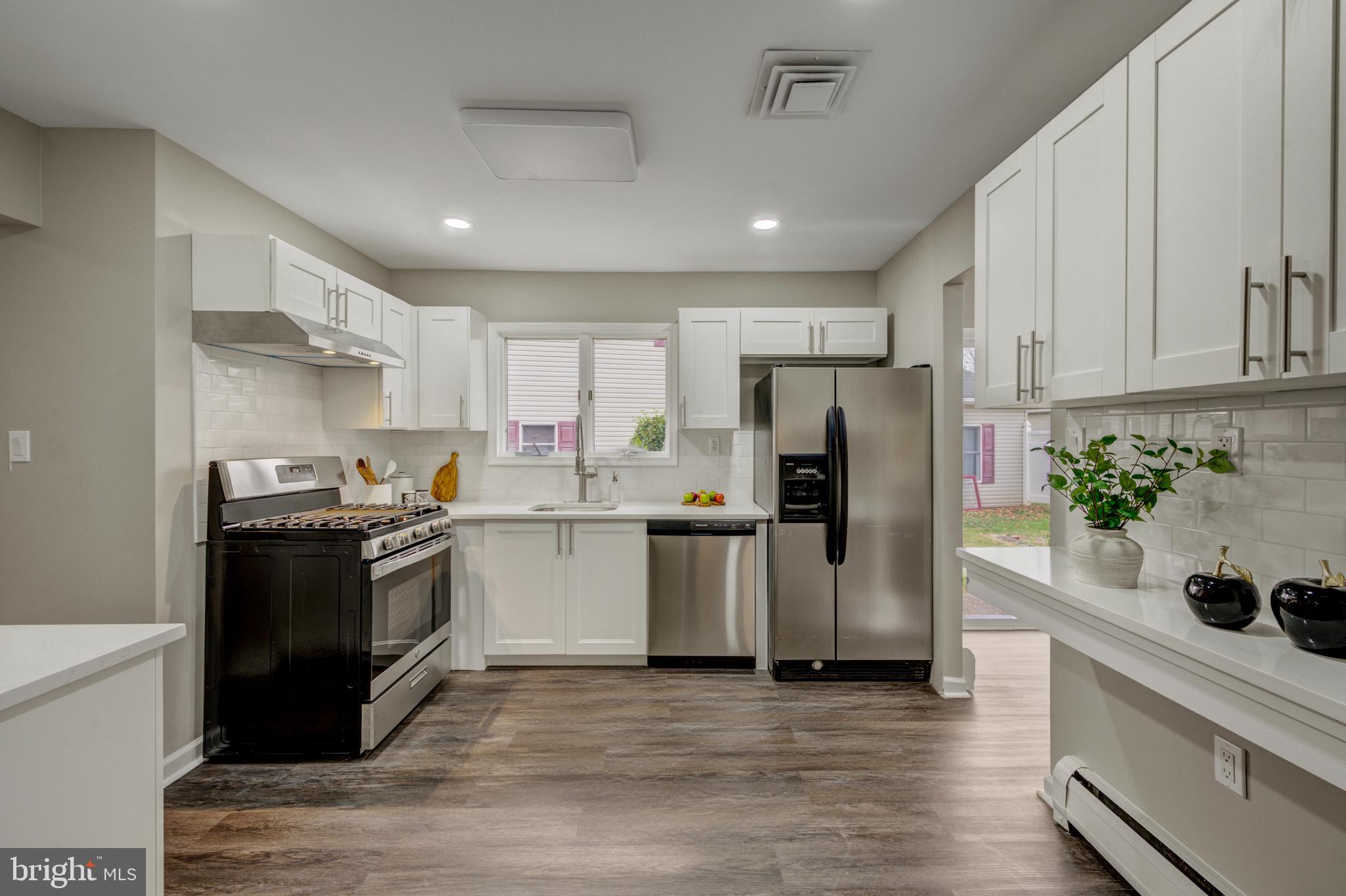 4255 Somerton Road Feasterville-Trevose, PA 19053 - Photo 8 of 37 a kitchen with a refrigerator stove and white cabinets