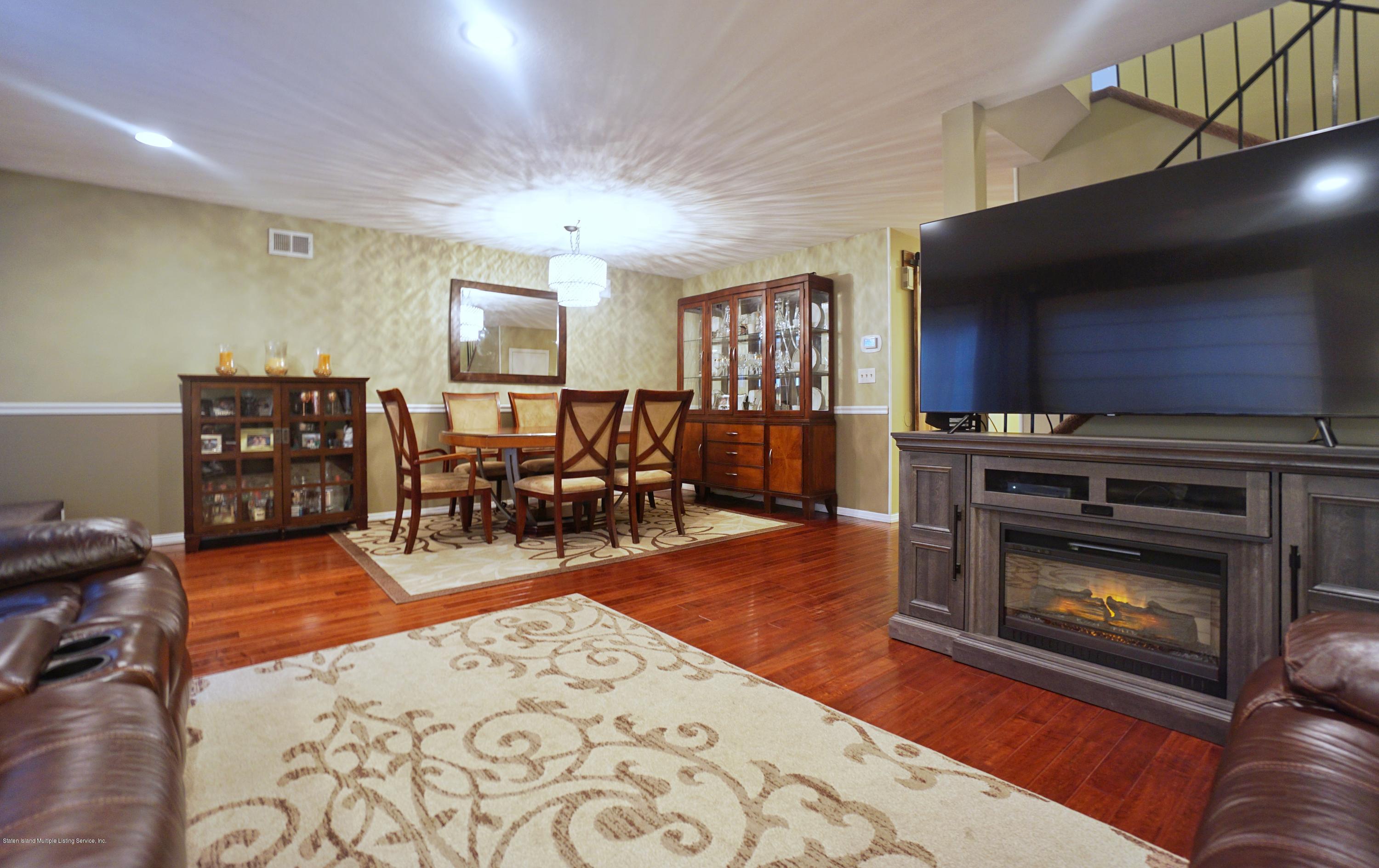 43 Forest Green Staten Island, NY 10312 - Photo 12 of 30 a living room with furniture a dining table and a fireplace