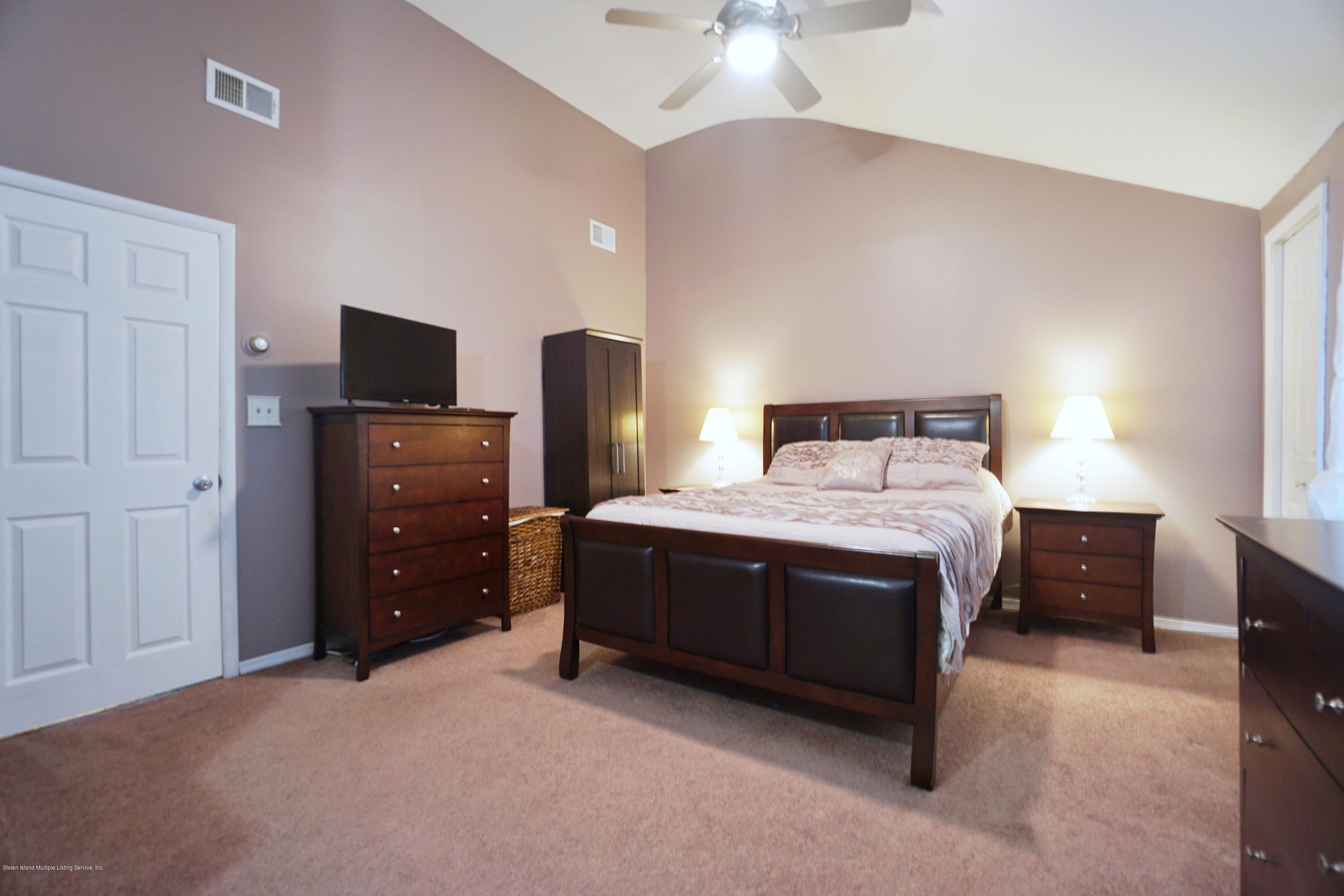 43 Forest Green Staten Island, NY 10312 - Photo 17 of 30 a bedroom with a bed and a flat tv screen on dresser