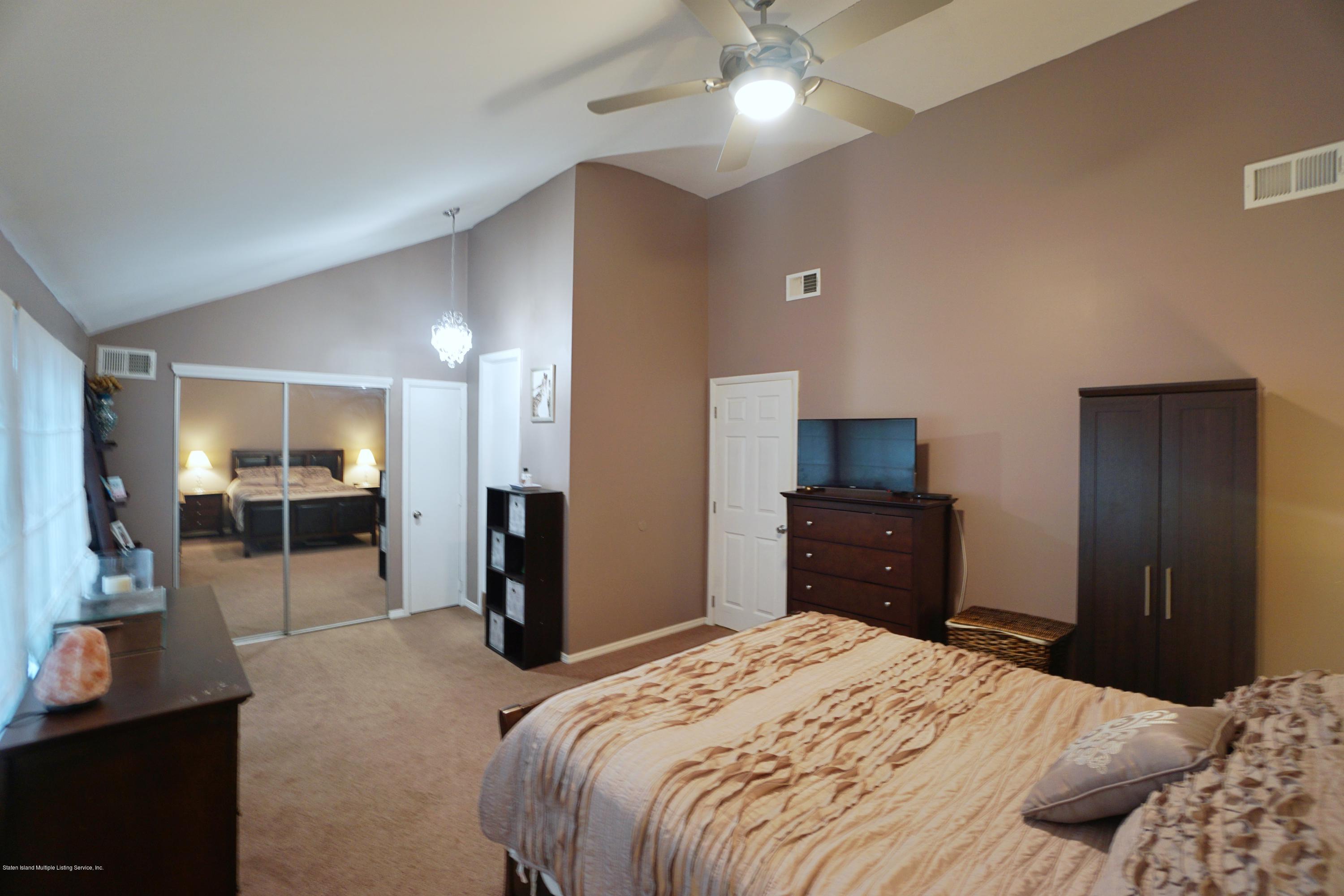 43 Forest Green Staten Island, NY 10312 - Photo 18 of 30 a bedroom with a bed and wooden floor