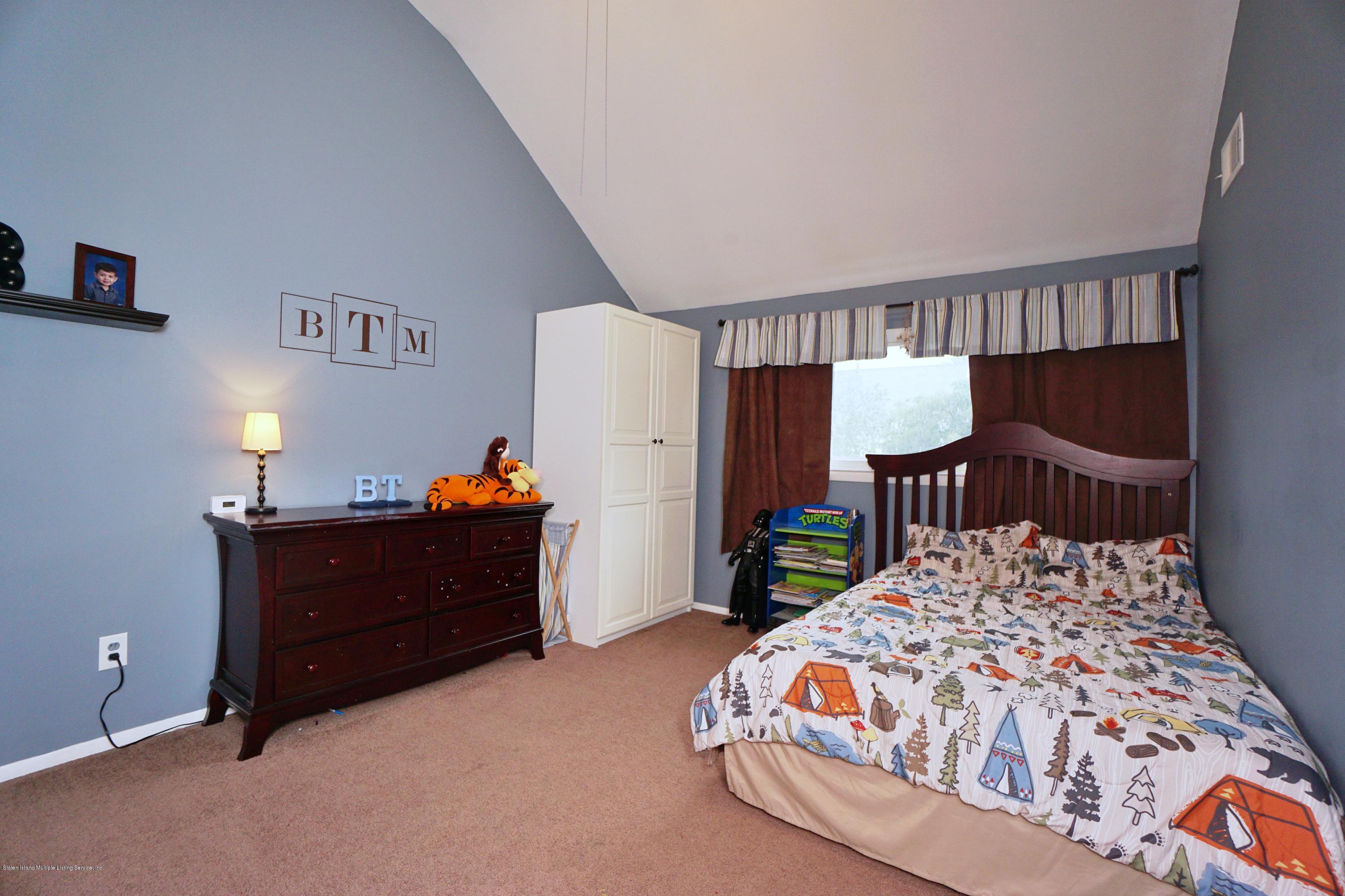43 Forest Green Staten Island, NY 10312 - Photo 23 of 30 a bedroom with a bed window and a table in it