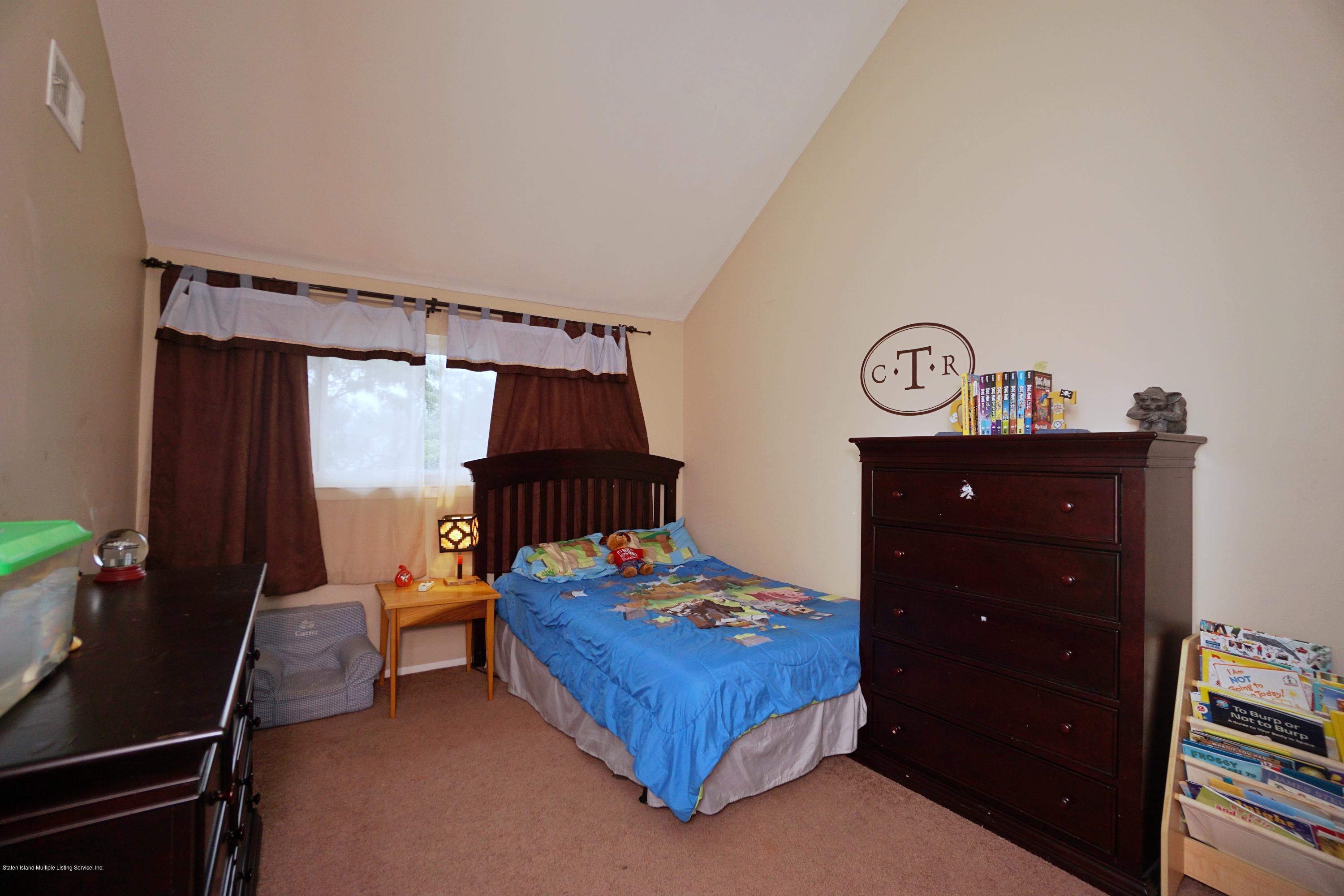 43 Forest Green Staten Island, NY 10312 - Photo 26 of 30 a bedroom with a bed and a table in it