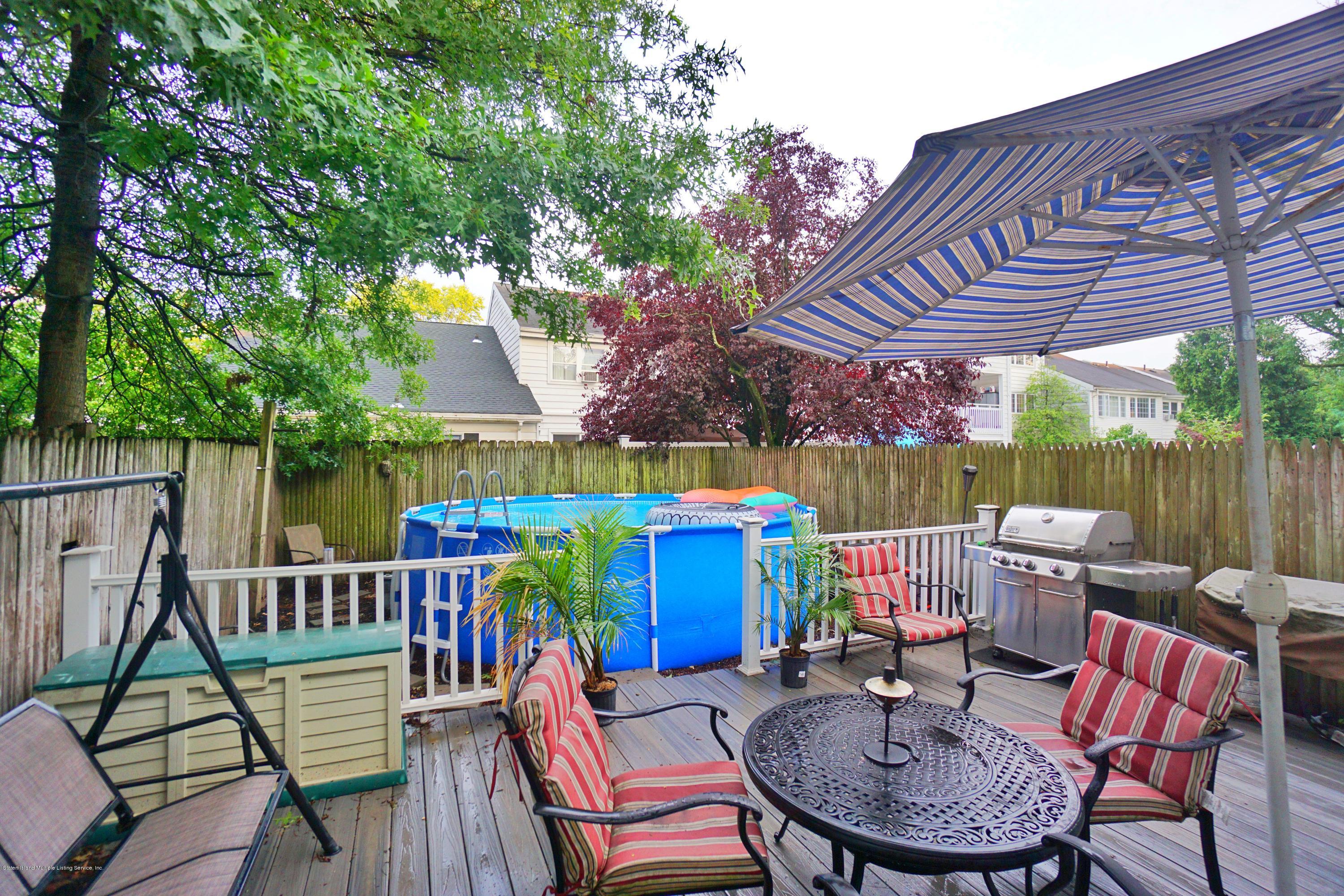 43 Forest Green Staten Island, NY 10312 - Photo 29 of 30 a patio with a table and chairs a barbeque