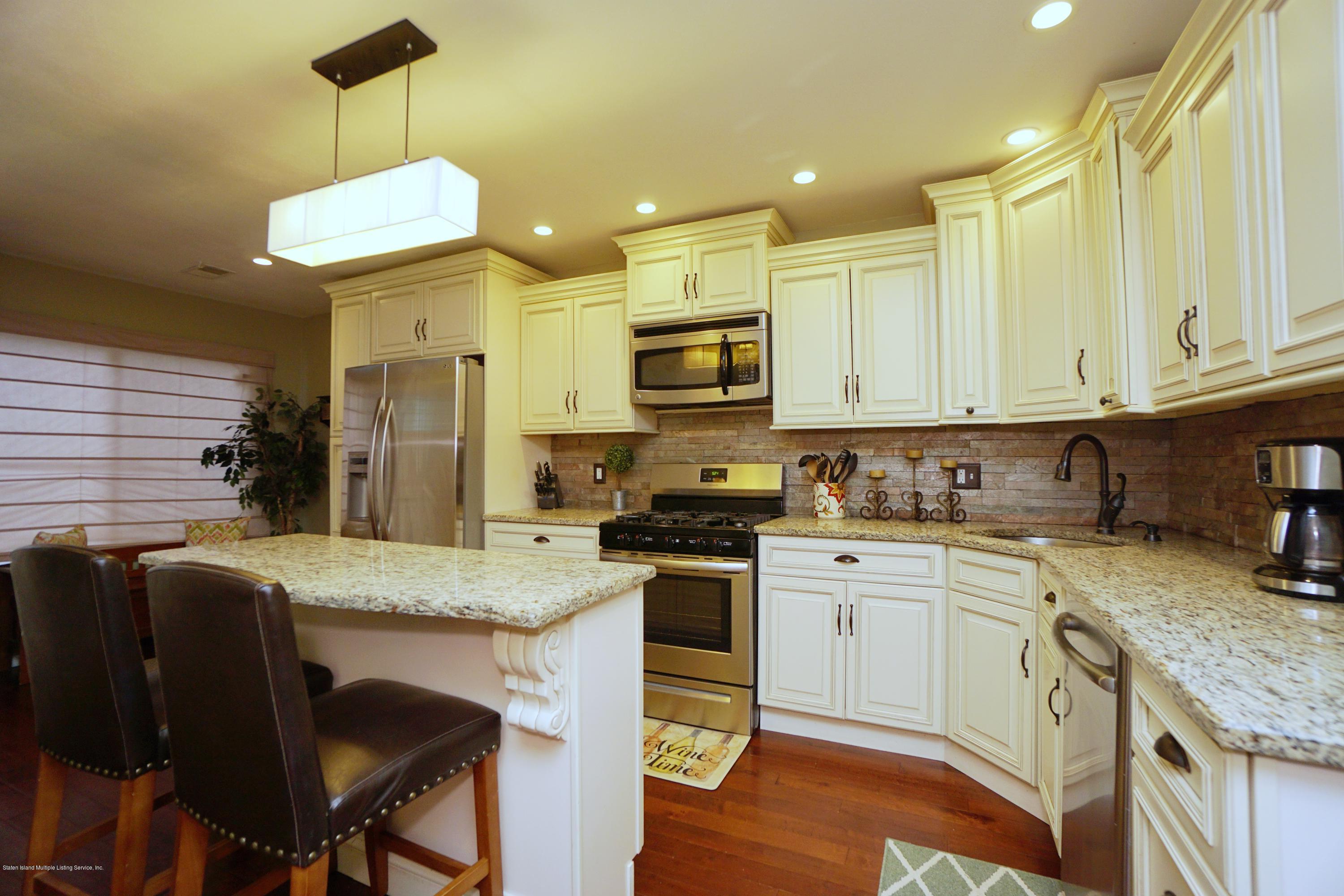 43 Forest Green Staten Island, NY 10312 - Photo 3 of 30 a kitchen with stainless steel appliances granite countertop a stove top oven a refrigerator a sink and a granite counter tops