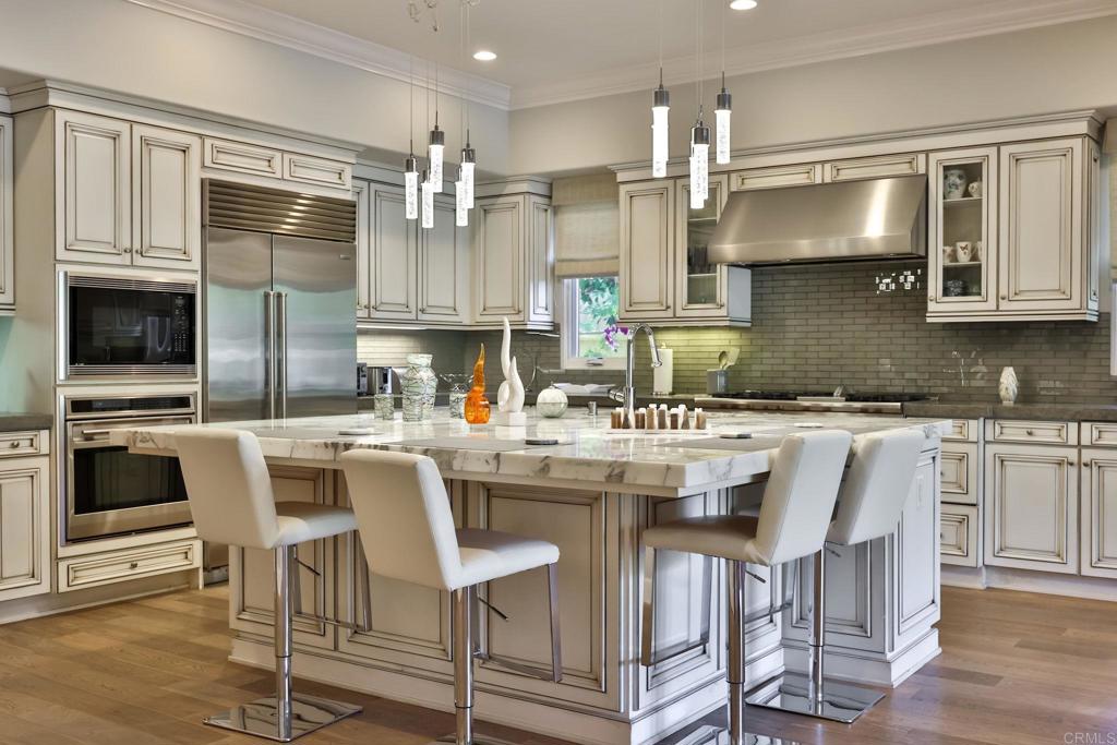 a kitchen with kitchen island granite countertop a stove and white cabinets