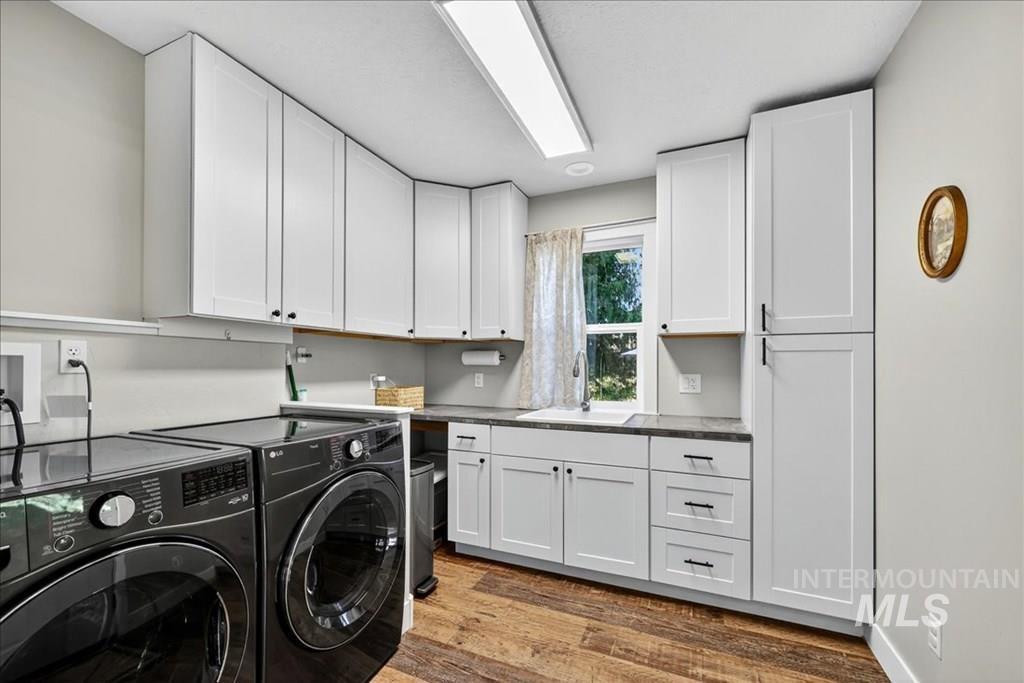 2651 Fruitvale Glendale Road Council, ID 83612 - Photo 14 of 25 Laundry area with cabinet space, washer and clothes dryer, and dark wood finished floors