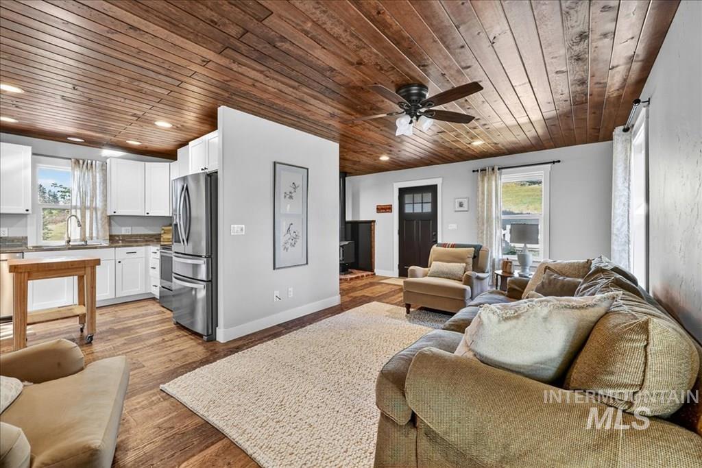 2651 Fruitvale Glendale Road Council, ID 83612 - Photo 6 of 25 Living room with light wood-type flooring, wood ceiling, and a ceiling fan