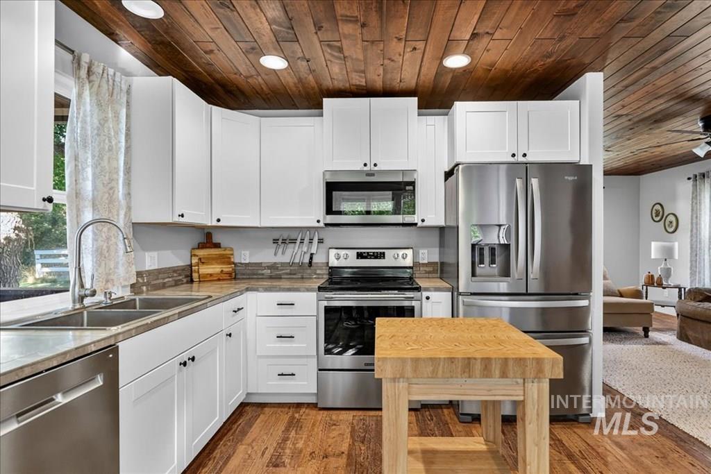 2651 Fruitvale Glendale Road Council, ID 83612 - Photo 9 of 25 Kitchen with stainless steel appliances, white cabinetry, ceiling fan, light wood-type flooring, and wood ceiling