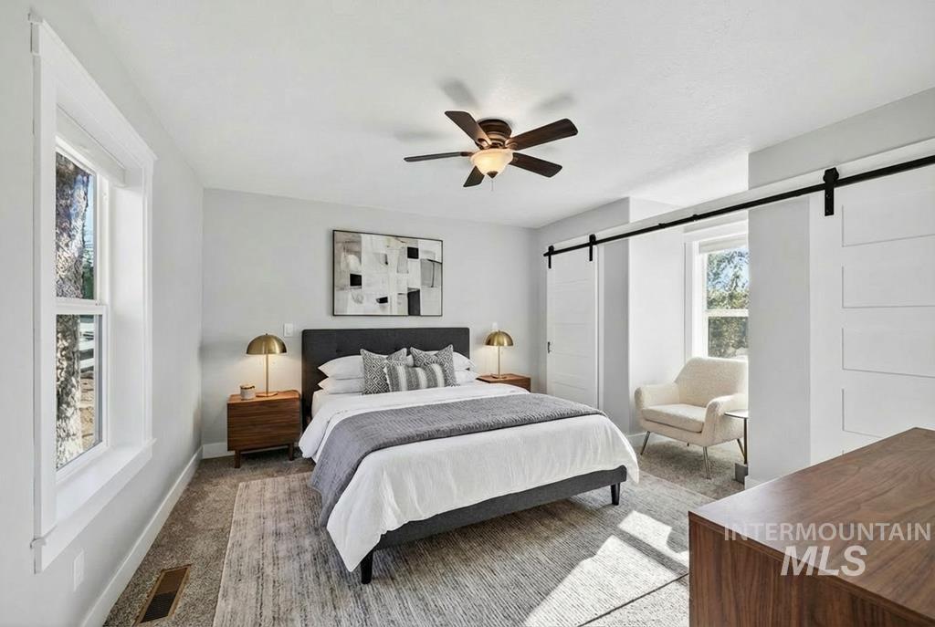 2651 Fruitvale Glendale Road Council, ID 83612 - Photo 10 of 25 Carpeted bedroom featuring a barn door and ceiling fan