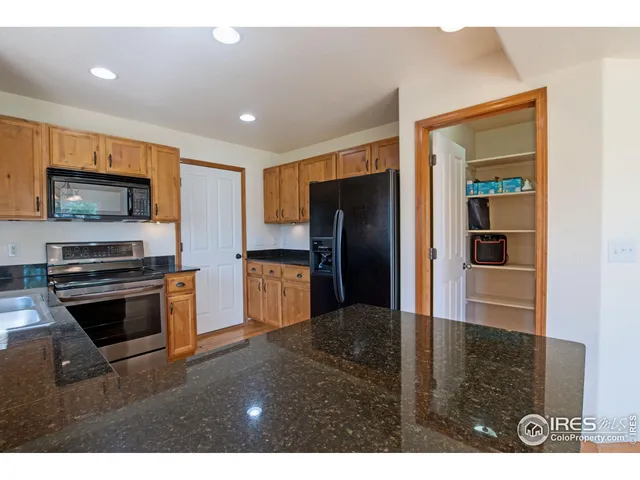 a kitchen with stainless steel appliances kitchen island granite countertop a refrigerator and a stove top oven