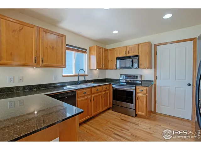 a kitchen with granite countertop a stove top oven sink and cabinets