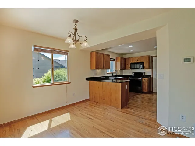 a kitchen with stainless steel appliances granite countertop a refrigerator a stove top oven a sink dishwasher and white cabinets with wooden floor