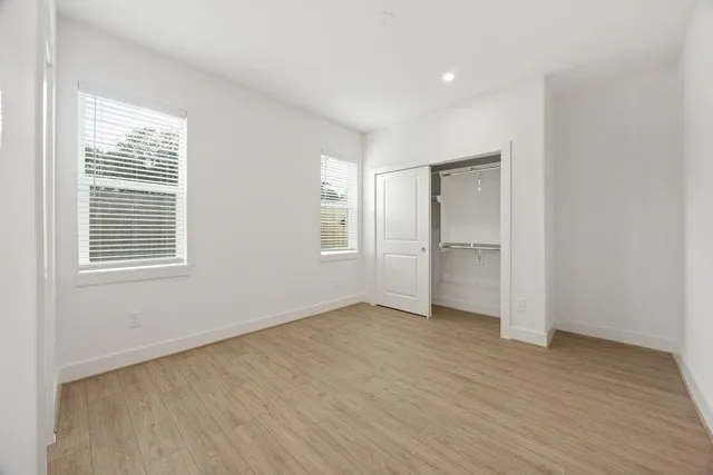 an empty room with windows and closet