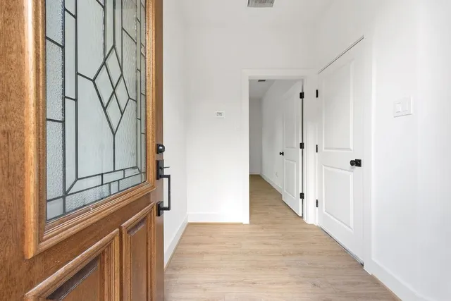 a view of a hallway with wooden floor and staircase