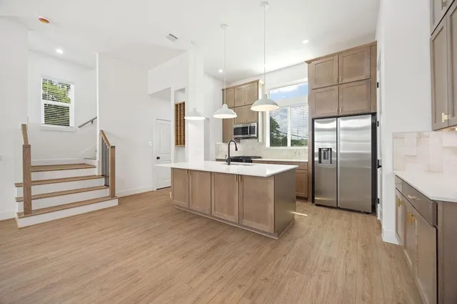 a kitchen with stainless steel appliances a refrigerator and a stove top oven