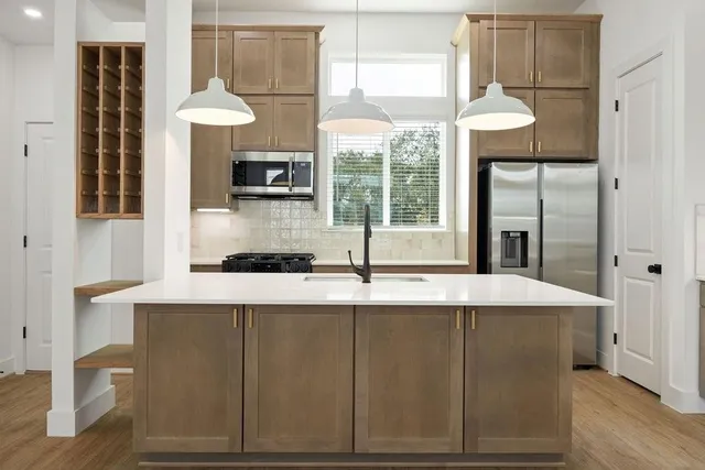 a kitchen with stainless steel appliances granite countertop a sink and a refrigerator
