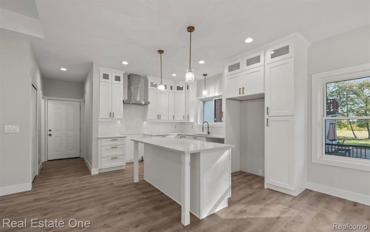 5636 Paris Street Sterling Heights, MI 48310 - Photo 13 of 37 Kitchen featuring glass insert cabinets, white cabinetry, and hanging light fixtures