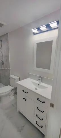 a bathroom with a sink toilet and mirror
